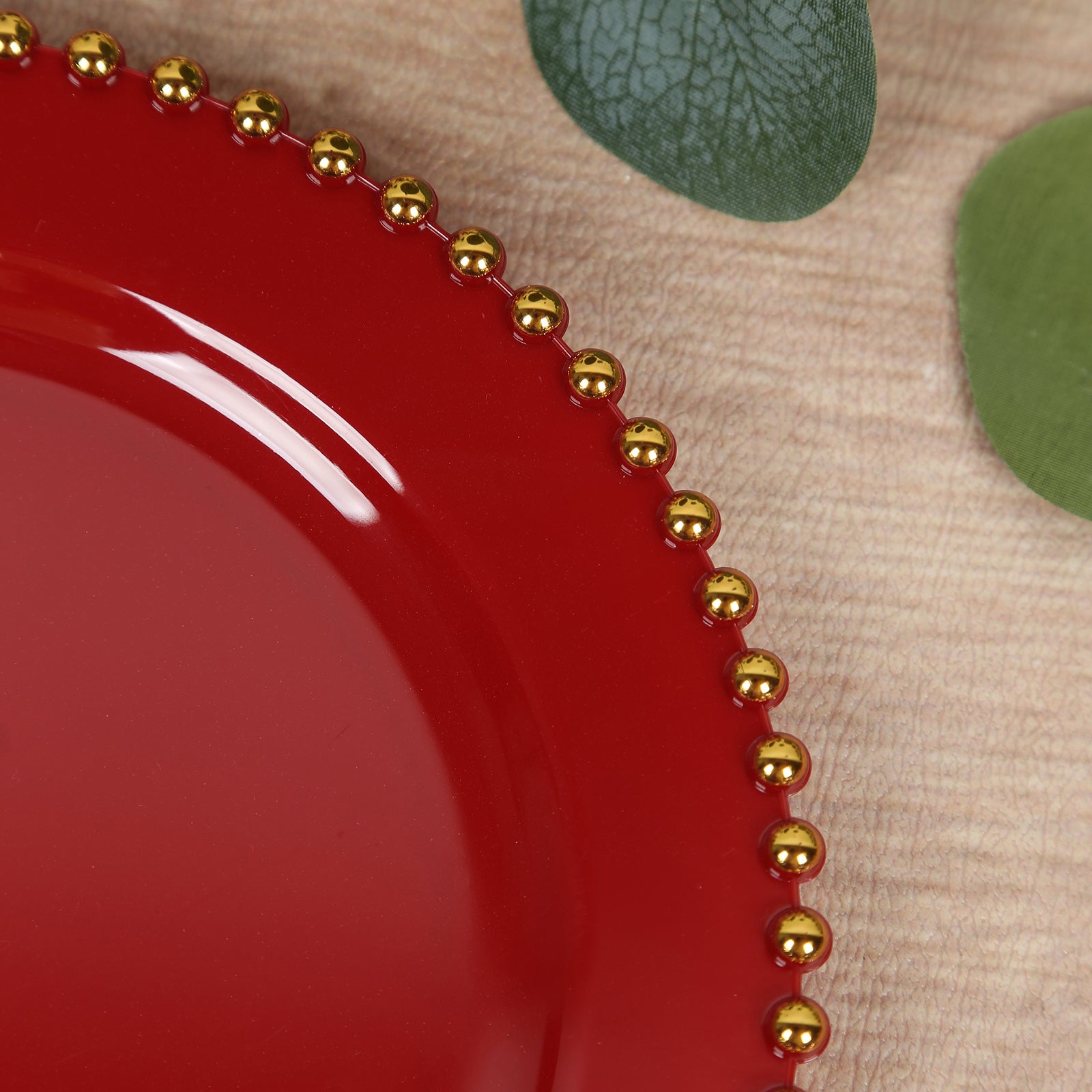 Red disposable dessert plate with gold beaded rim, perfect for parties.