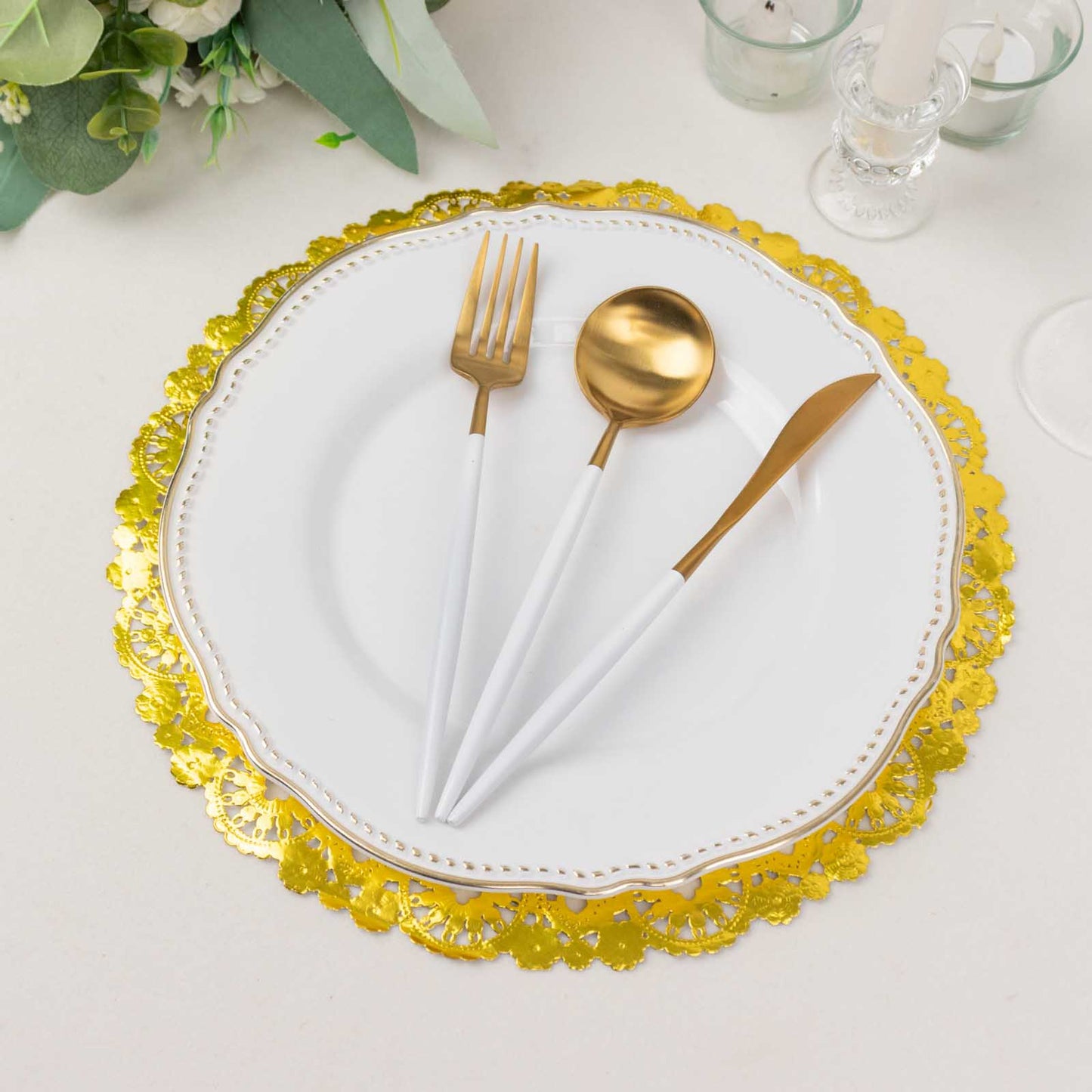 Metallic gold paper lace doily placemat with white and gold utensils.