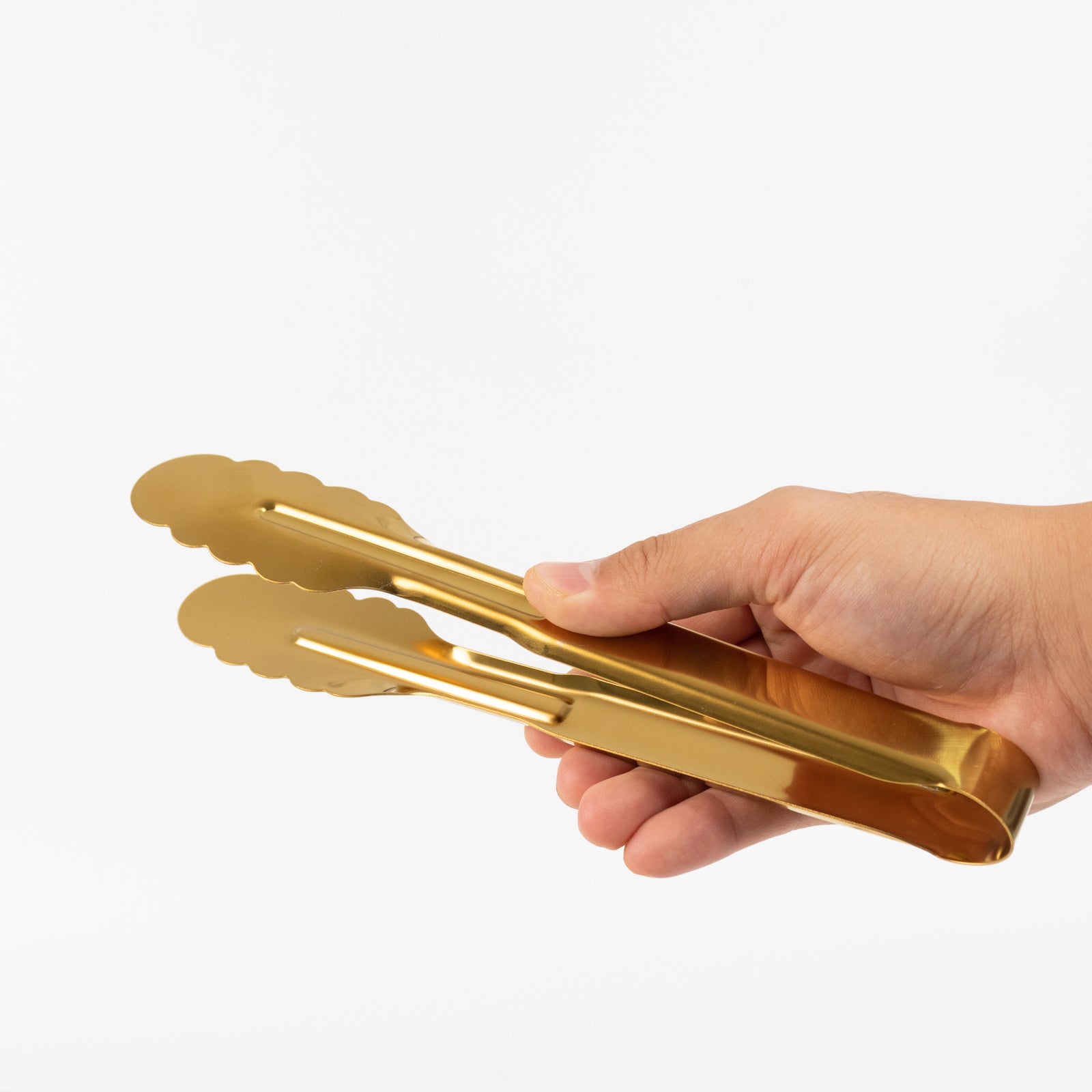 Gold metal kitchen tongs with scalloped edge for easy gripping.