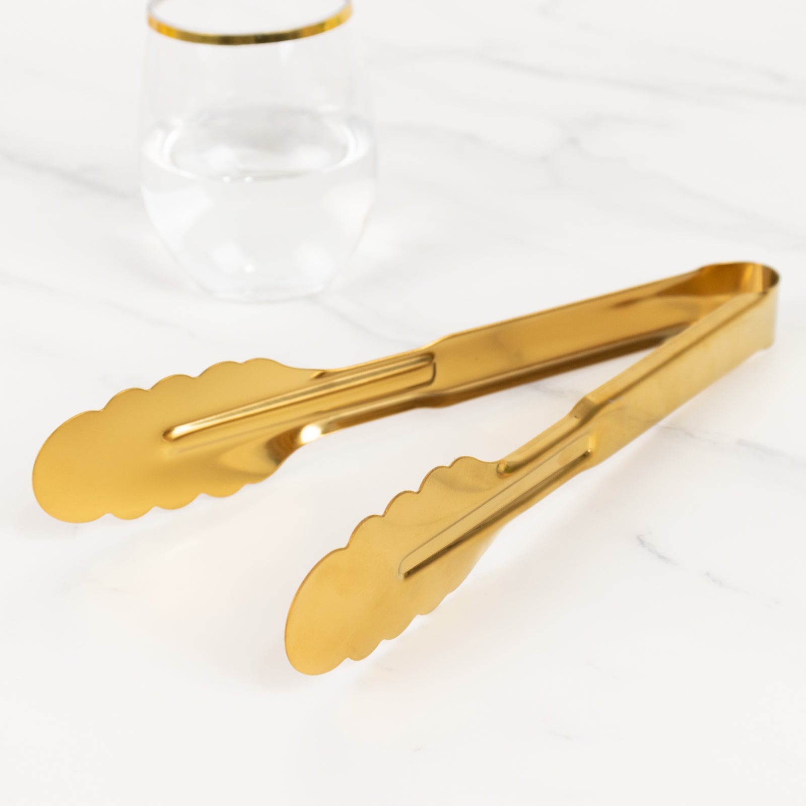 Gold metal kitchen tongs with scalloped edge and easy grip.