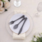 Transparent black disposable cutlery set on a white plate with elegant decor.