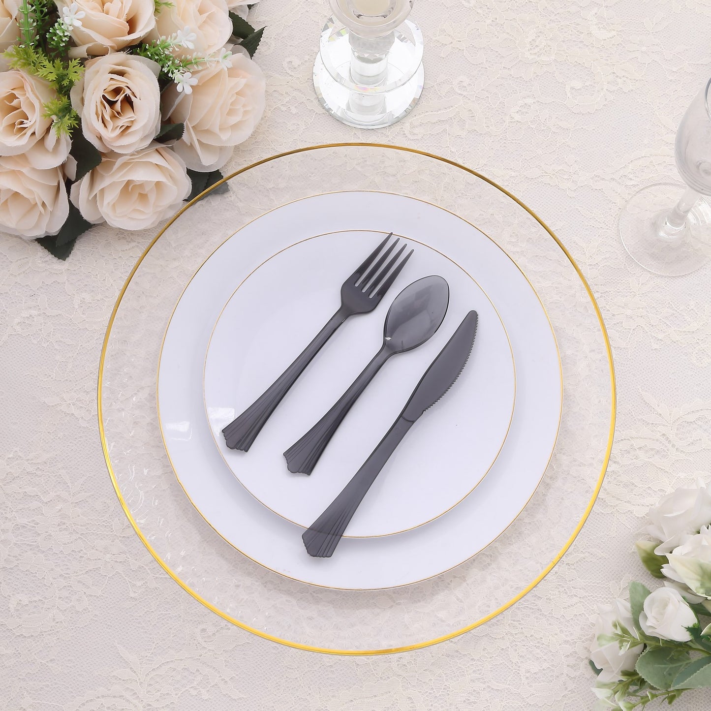 Transparent black disposable cutlery set on a white plate with gold rim.