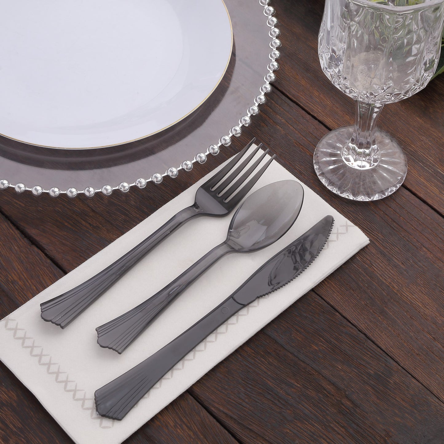 Transparent black disposable plastic cutlery set with fan flared tip handle.