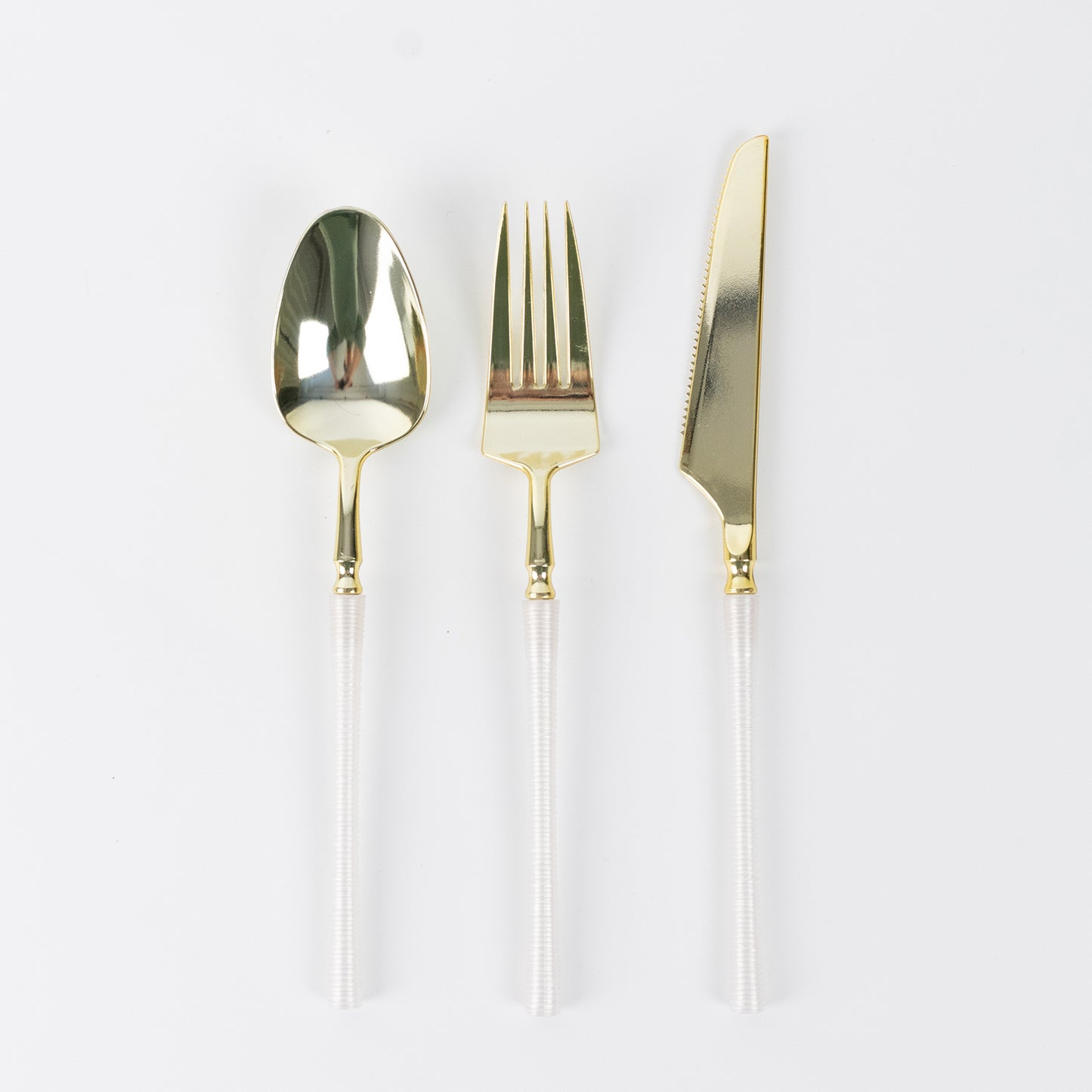 Gold plastic cutlery set with white handles, including spoon, fork, and knife.