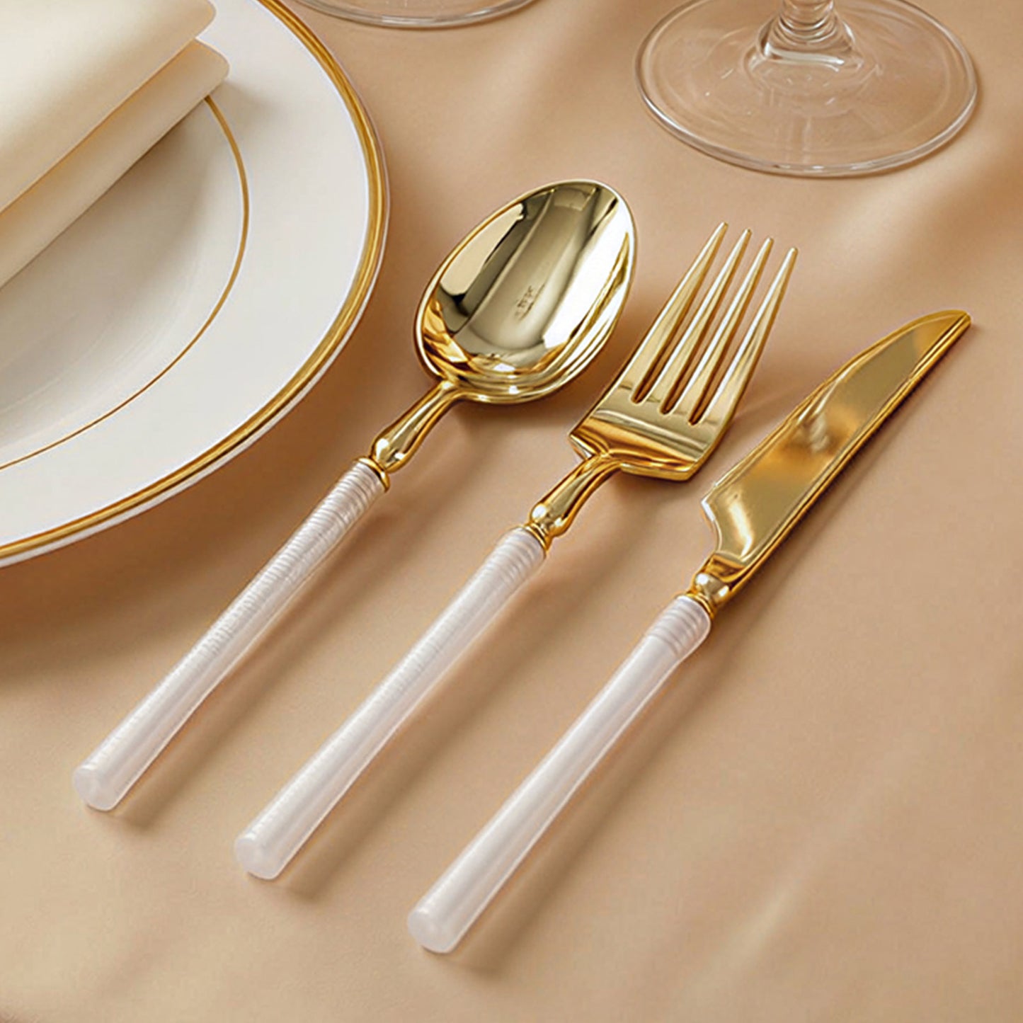 Gold plastic cutlery set with white handles, modern minimalist style.