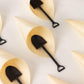 Black mini shovel spoons in dessert cones, perfect for ice cream or treats.