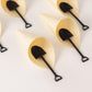 Black mini shovel spoons in dessert cones, perfect for ice cream servings.