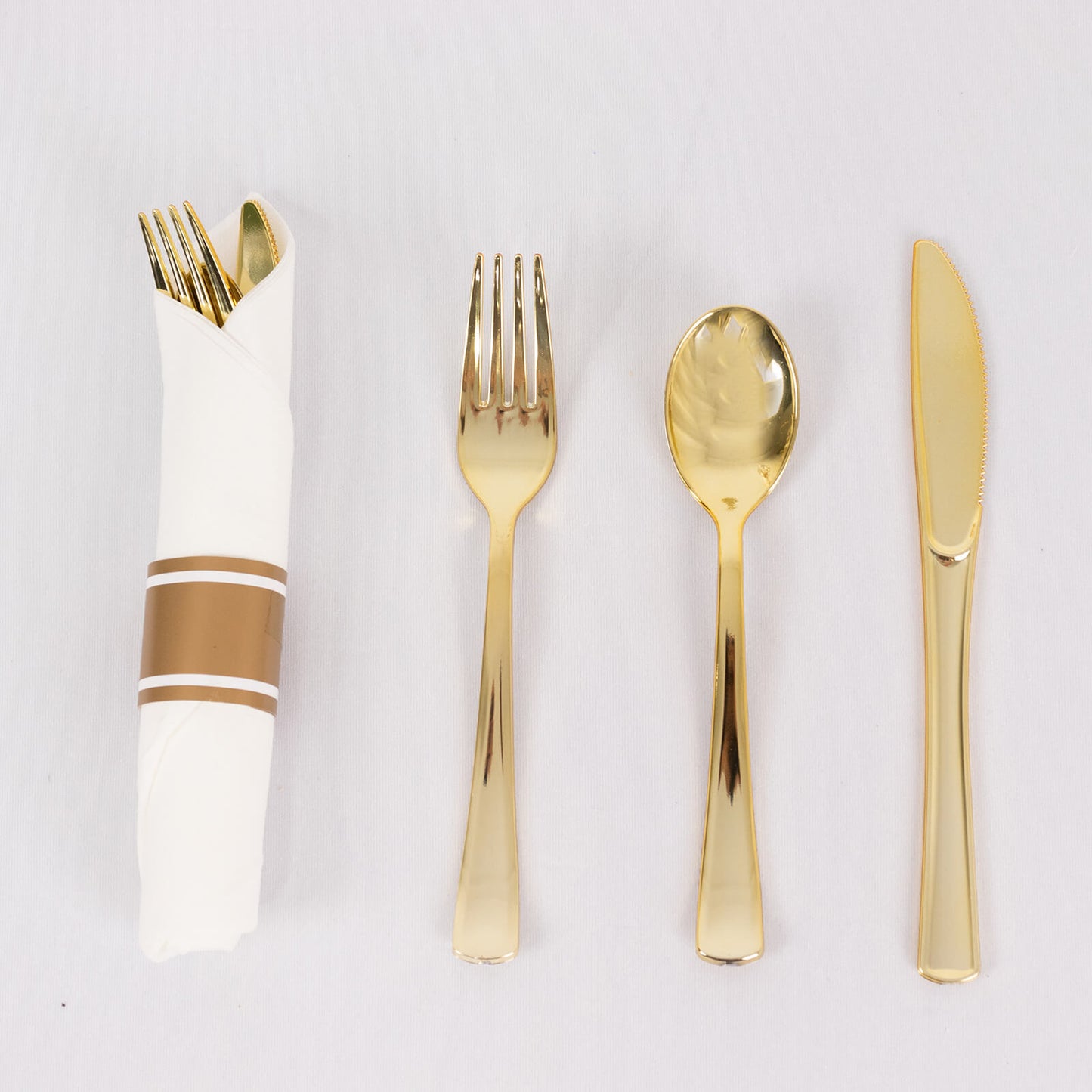Gold disposable cutlery set with white napkin, wrapped and elegant.