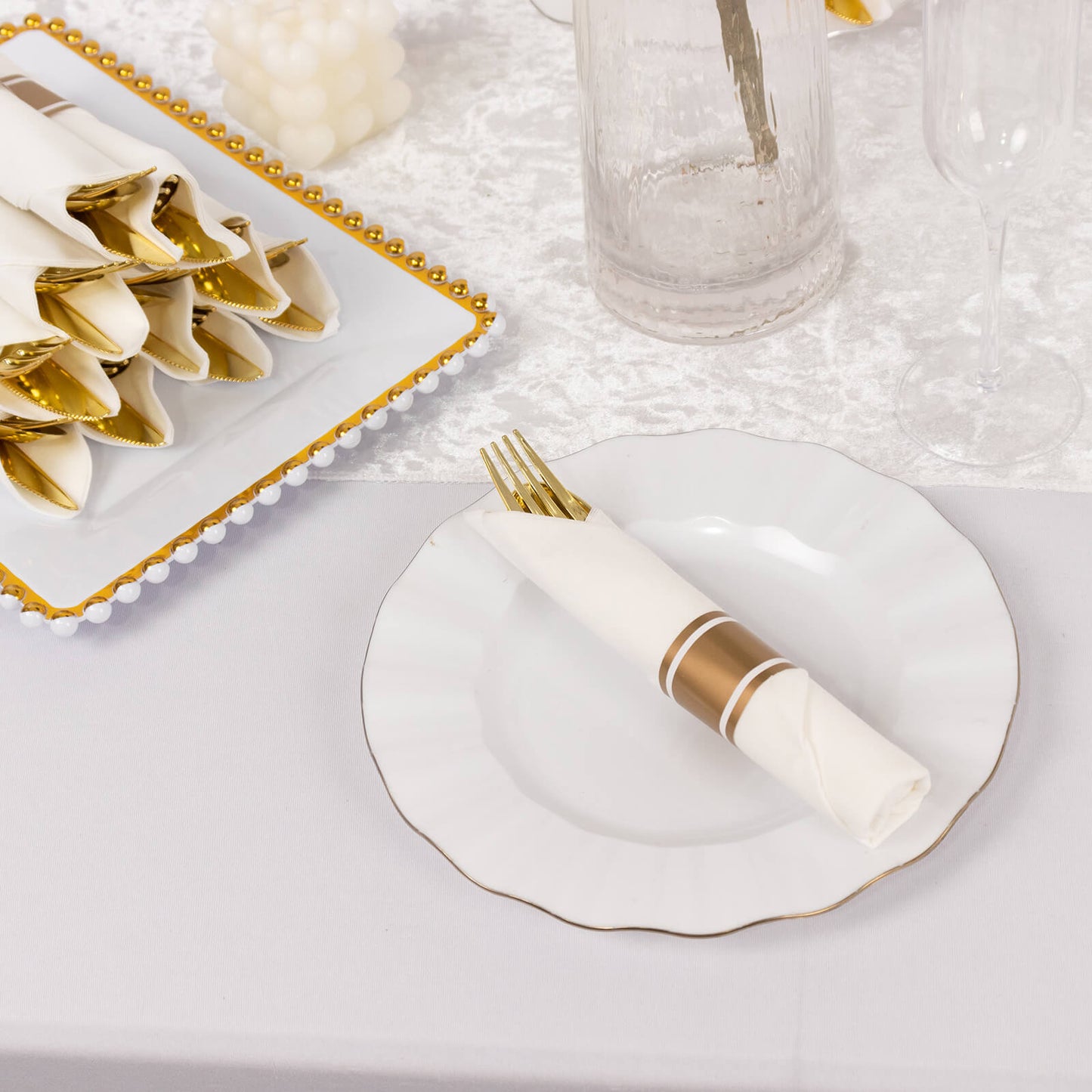 Gold disposable cutlery set with white napkins on a table setting.