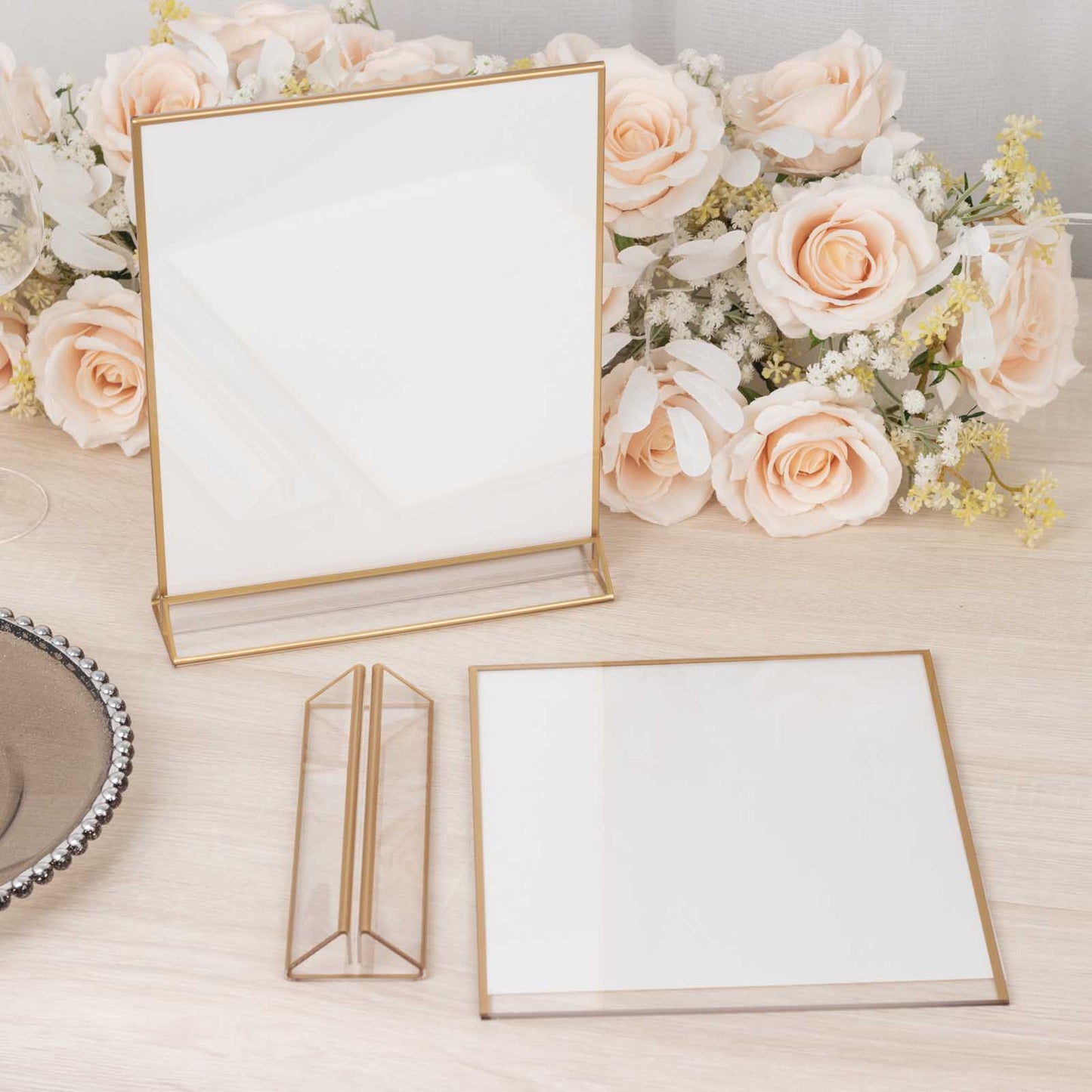 Gold acrylic table display stands with clear holders and white cardboard.