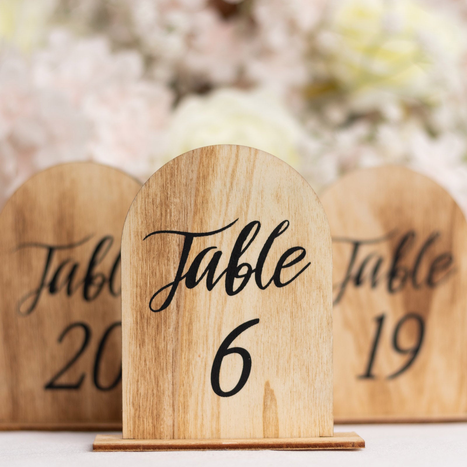 Natural wood table number 6 with rustic design, perfect for weddings and events.