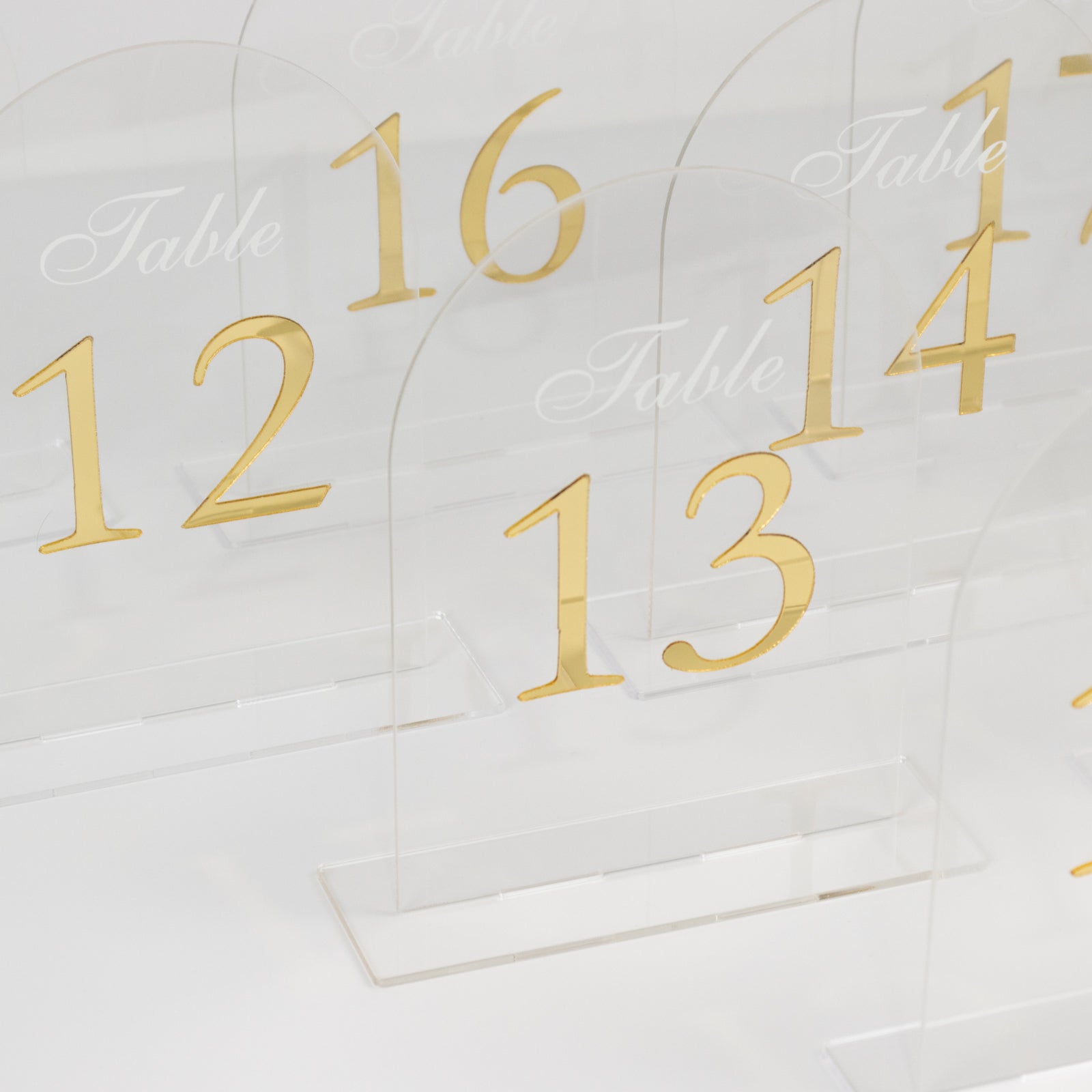 Clear arch acrylic table numbers with gold print, numbers 11-20.