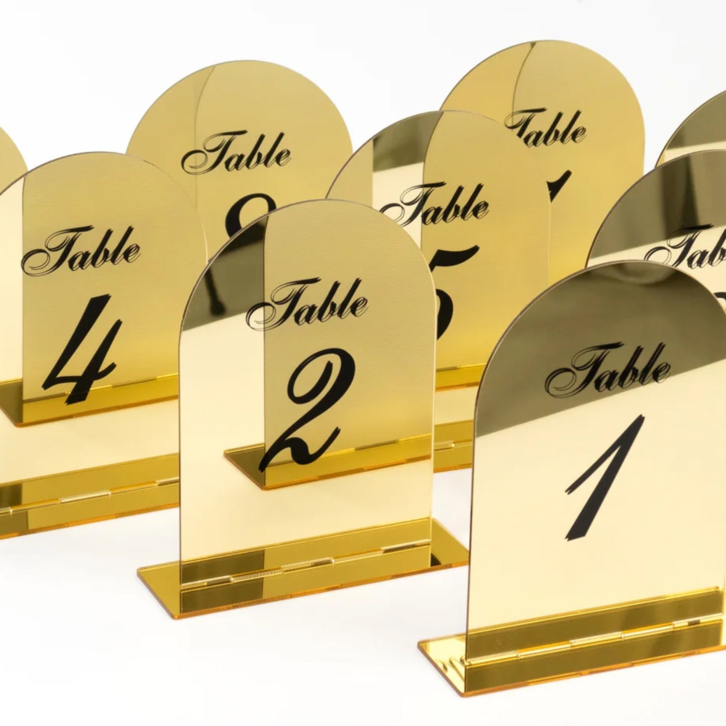 Gold mirror arch acrylic table numbers with black print.