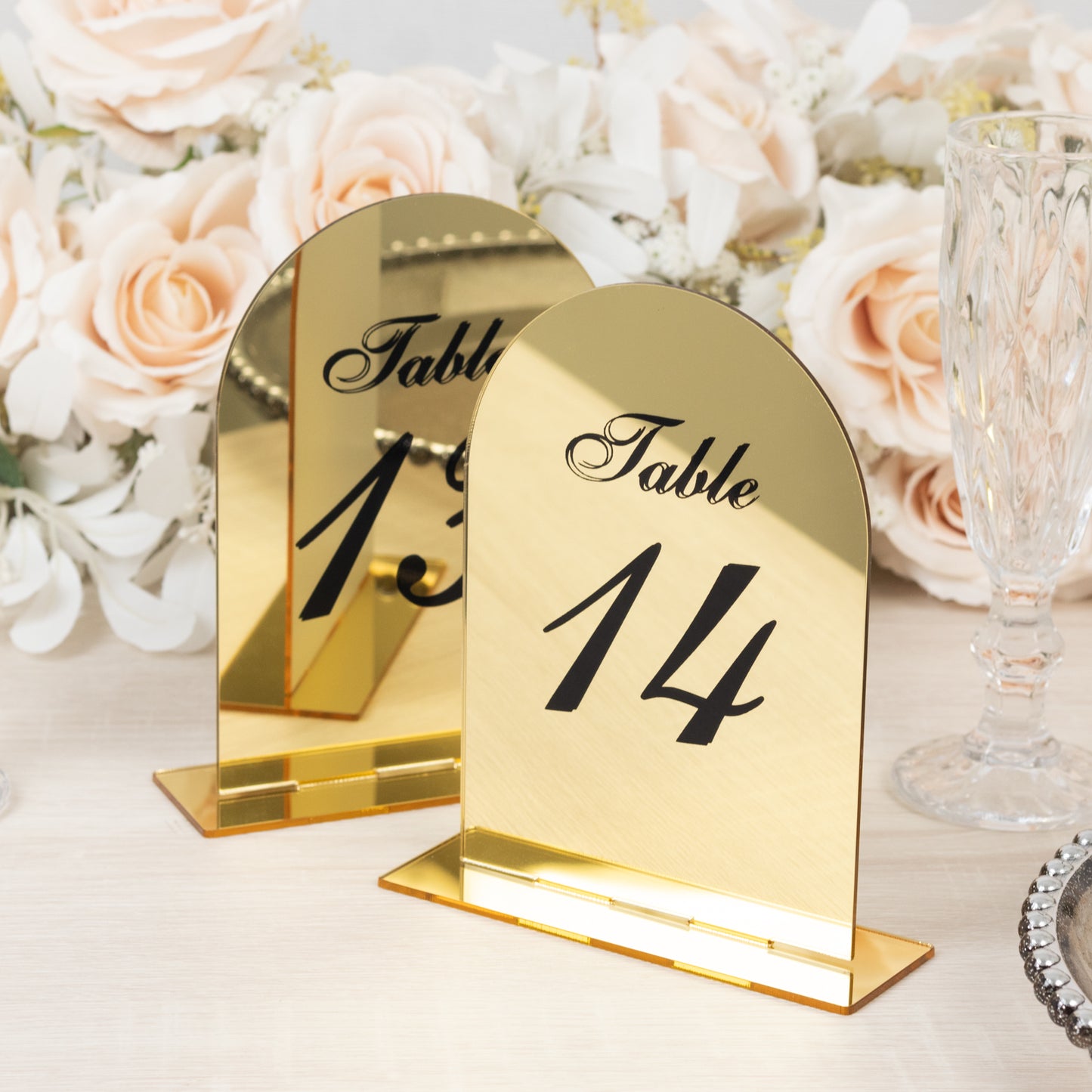 Gold mirror arch table number sign with black print, wedding reception decor.
