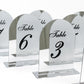 Silver mirror table numbers with black print for weddings.