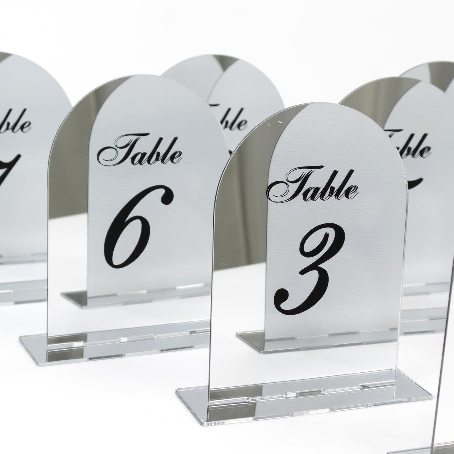 Silver mirror table numbers with black print for weddings.