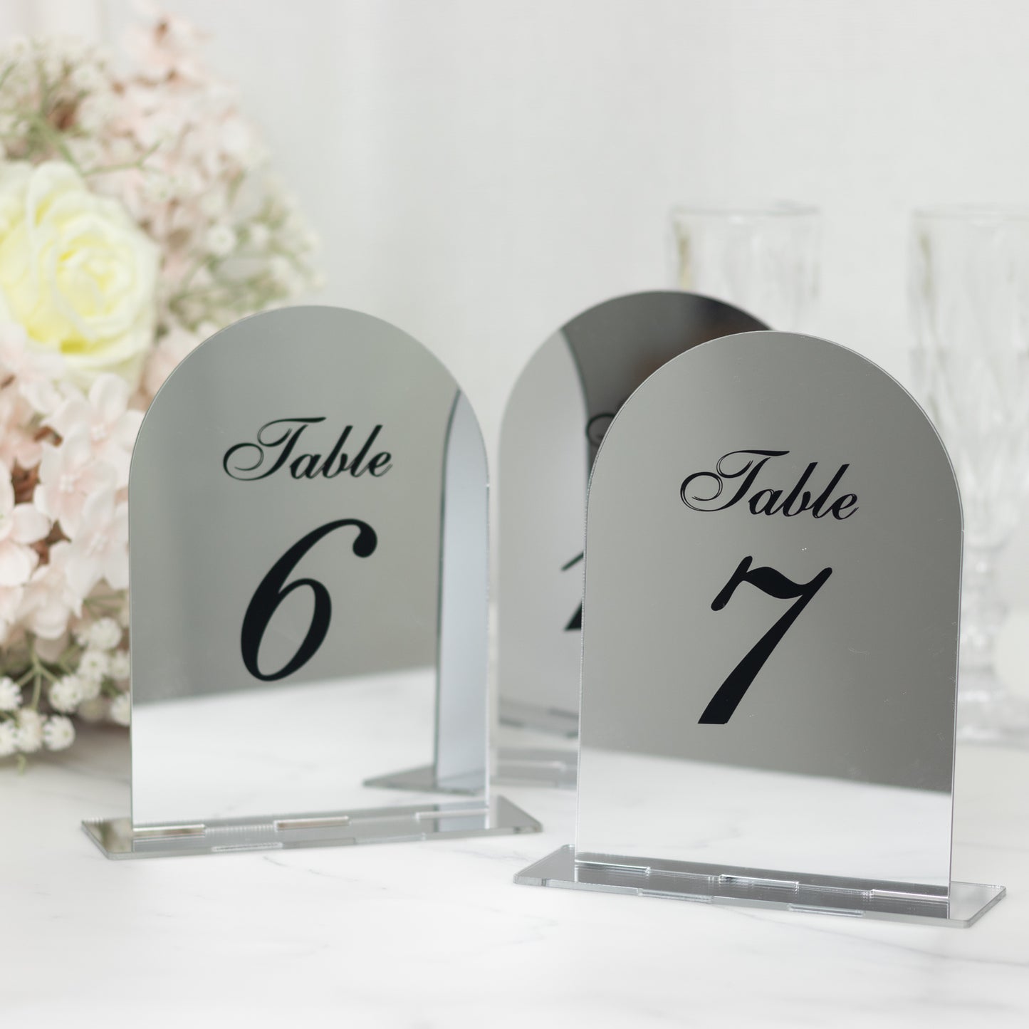 Silver mirror arch table numbers 6 and 7 with black print.