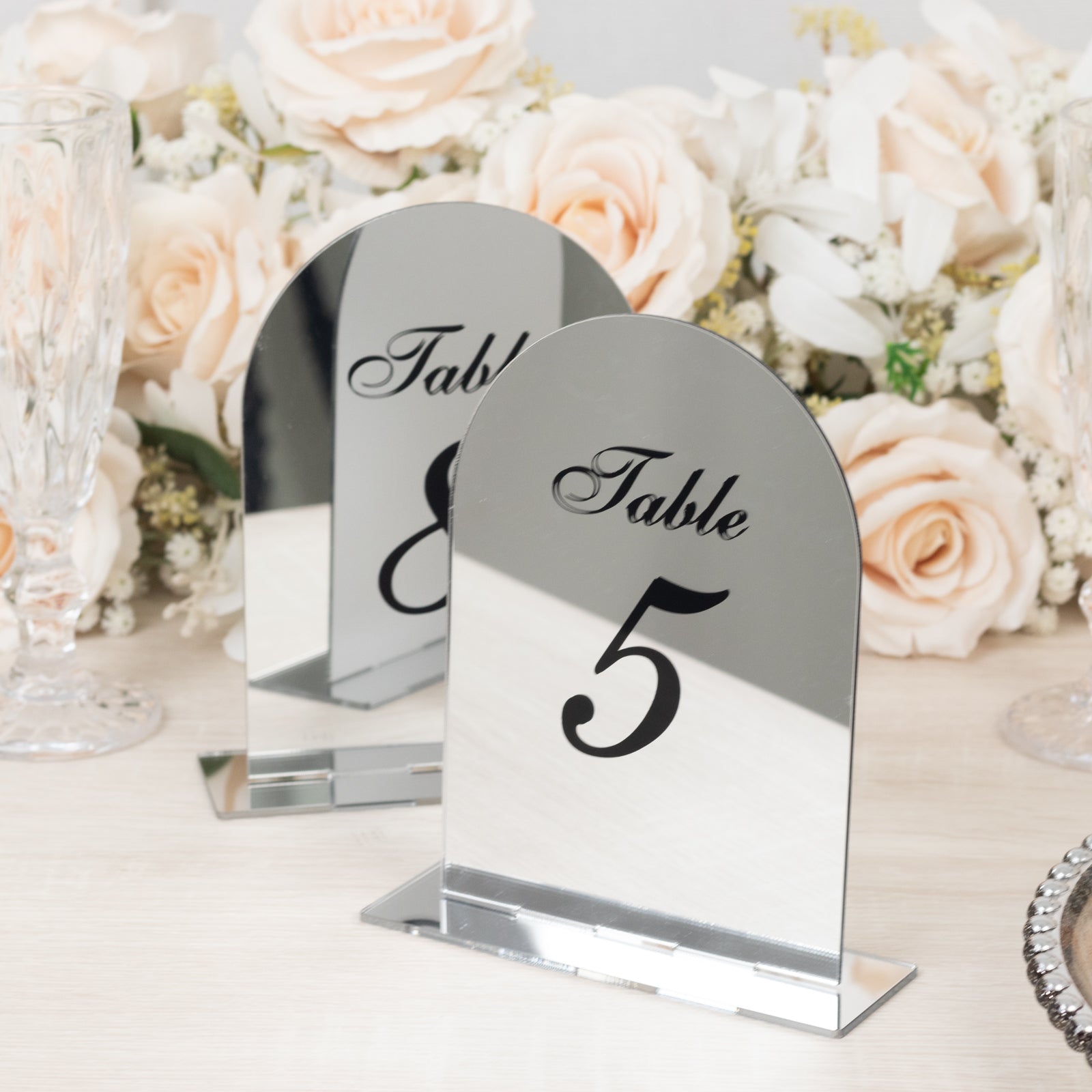 Silver mirror table numbers with black print, elegant wedding decor.