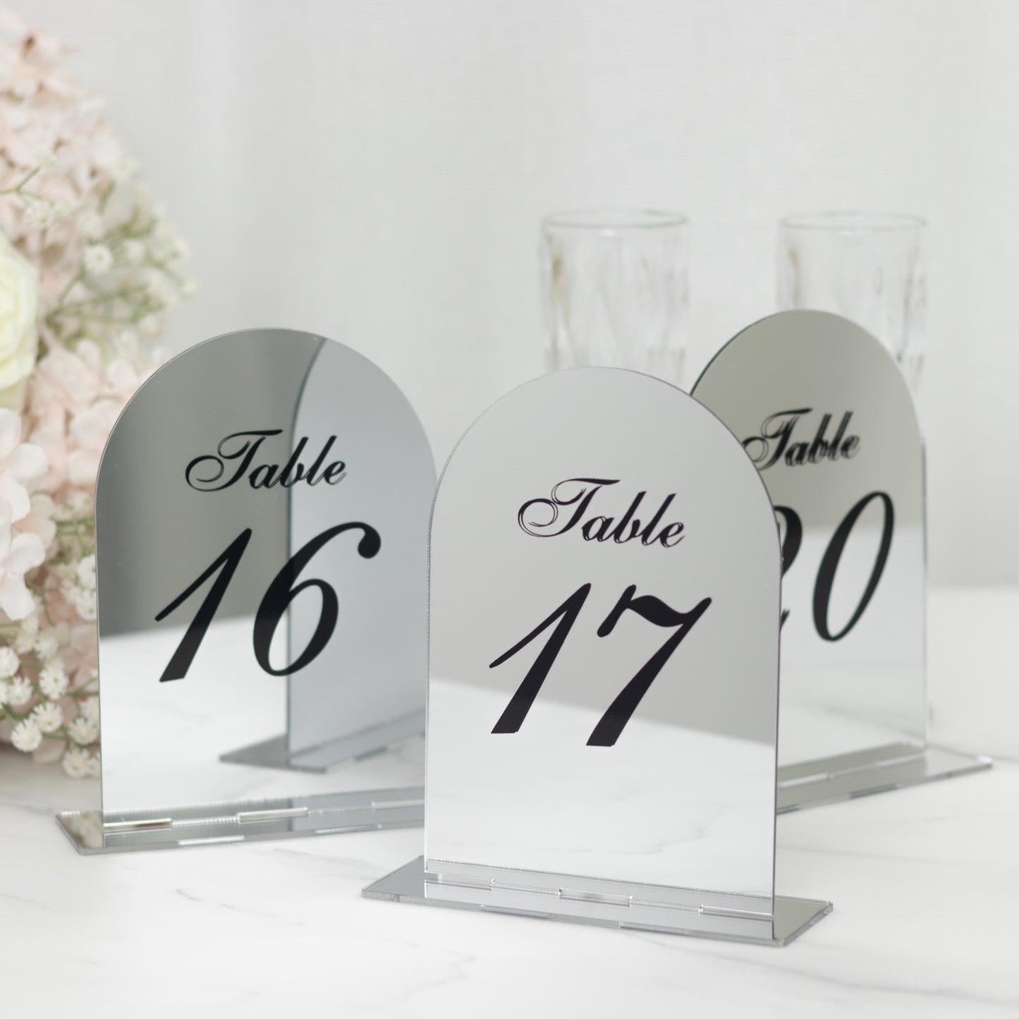Silver mirror table numbers 16 and 17 with black print on a decorative stand.