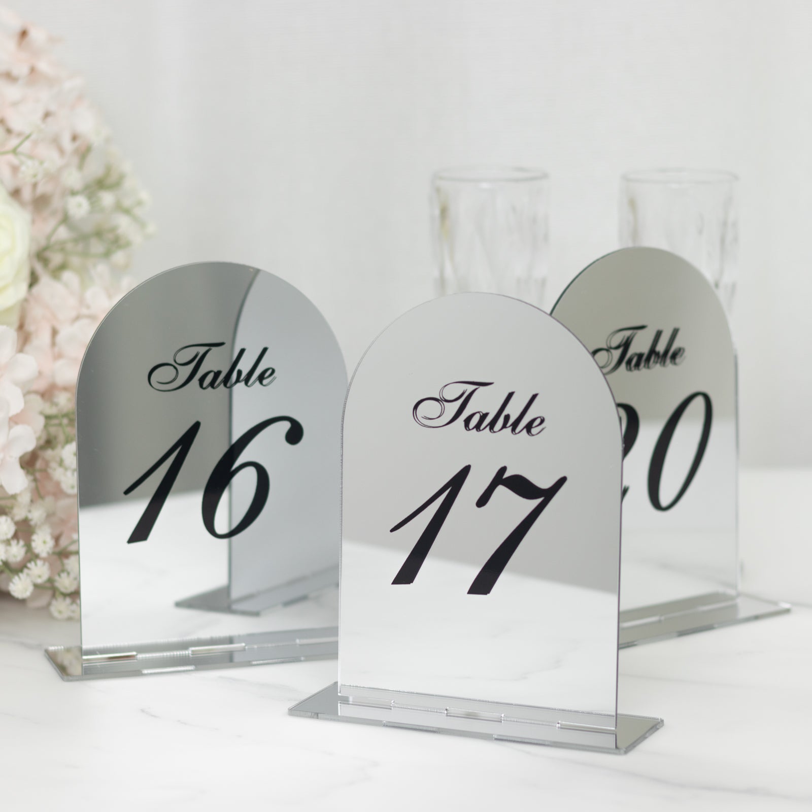 Silver mirror table numbers 16 and 17 with black print on a decorative stand.