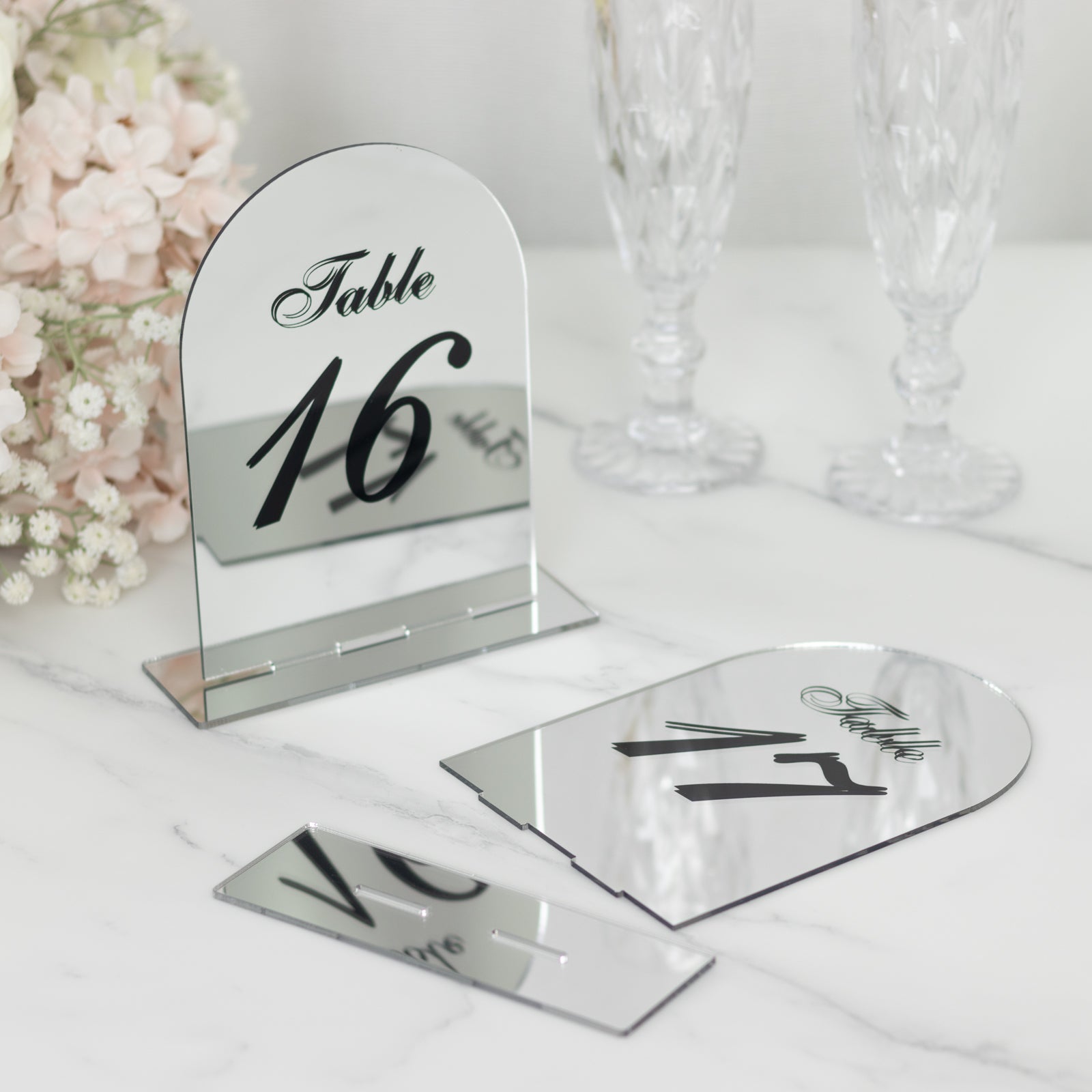 Silver mirror arch table numbers with black print for wedding reception.