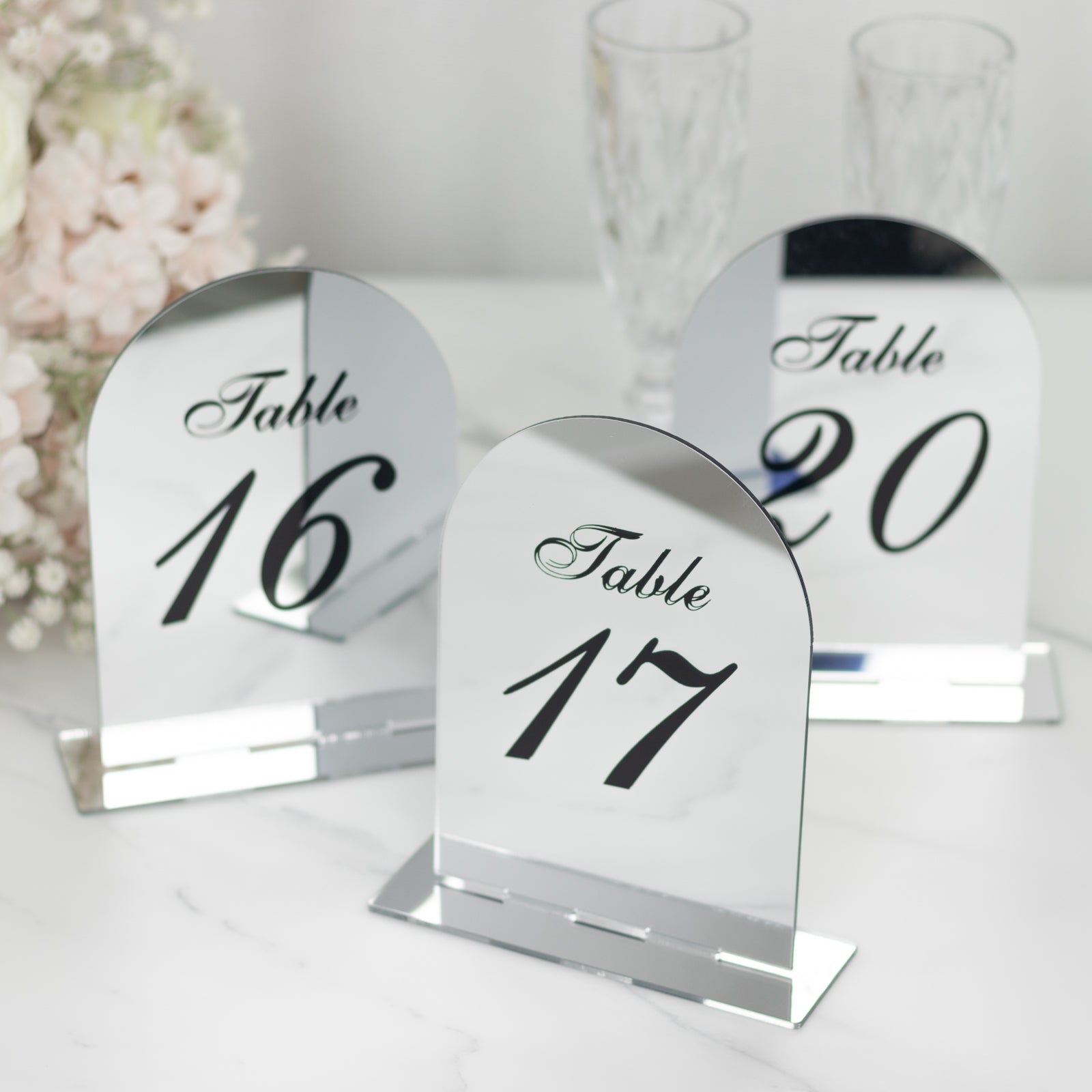 Silver mirror arch table numbers with black print for weddings.