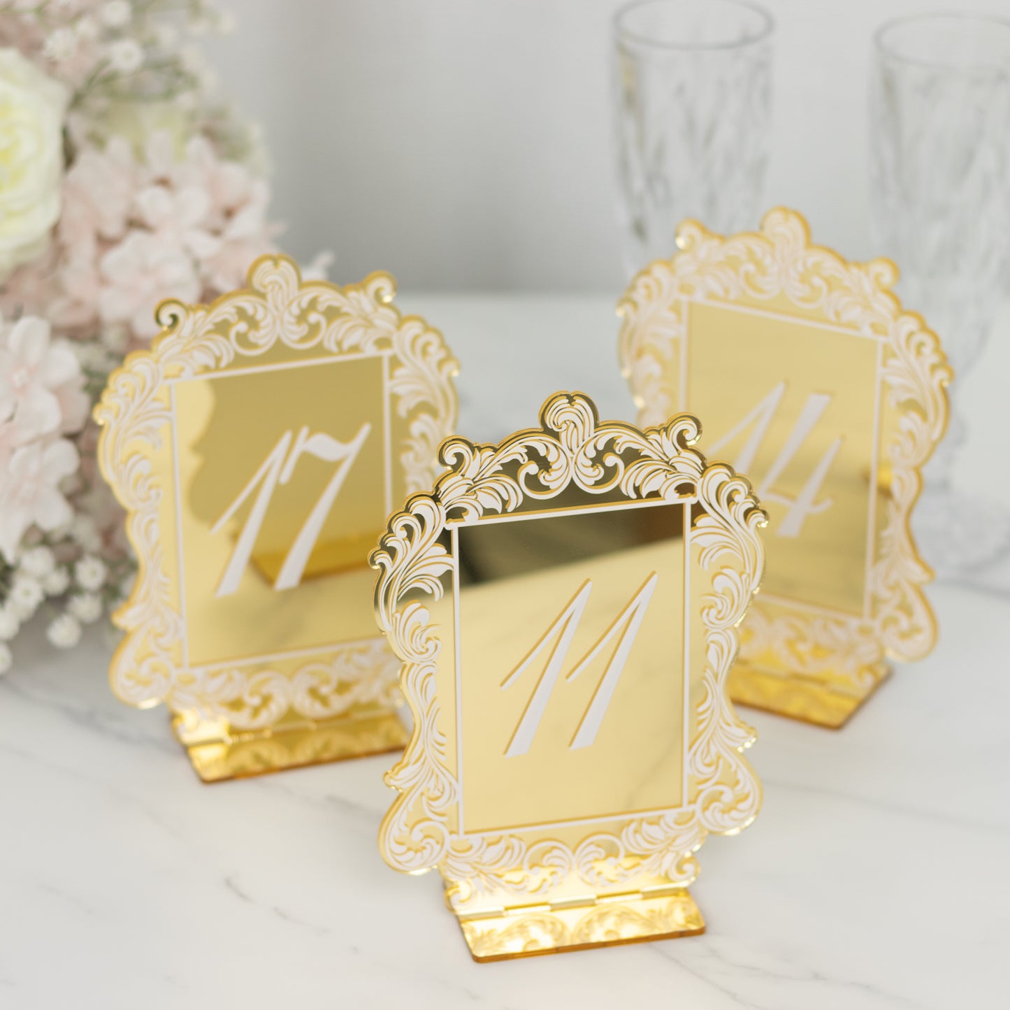 Gold mirror arch table numbers with baroque lace border for wedding reception.