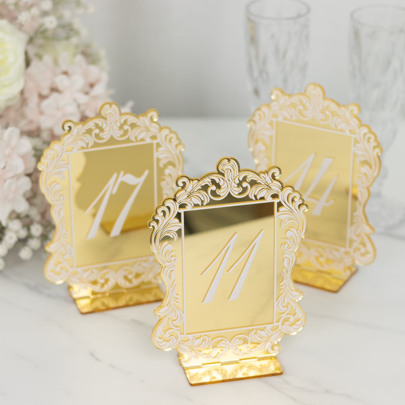 Gold mirror arch table numbers with baroque lace border for wedding reception.