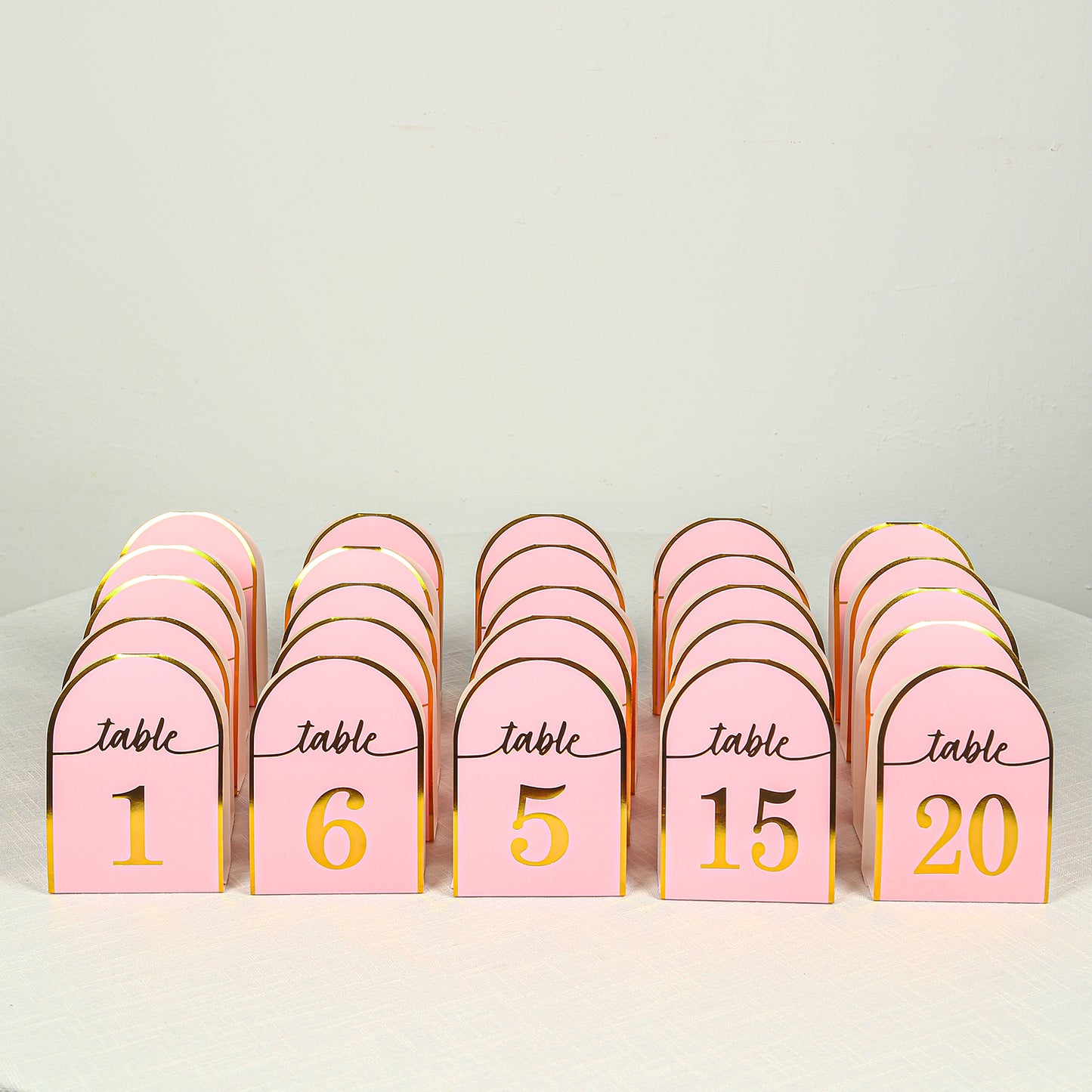 Blush pink disposable table numbers with metallic gold foil, numbers 1-25.