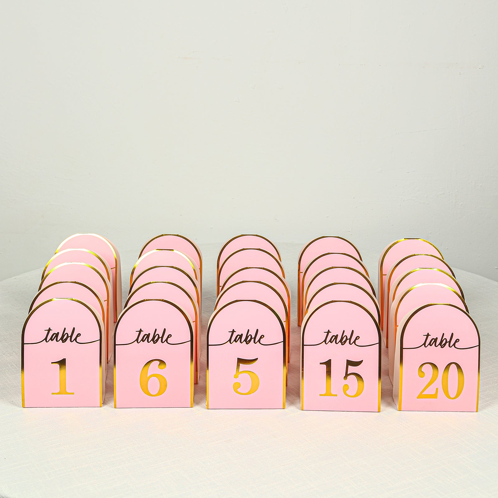 Blush pink disposable table numbers with metallic gold foil, numbers 1-25.