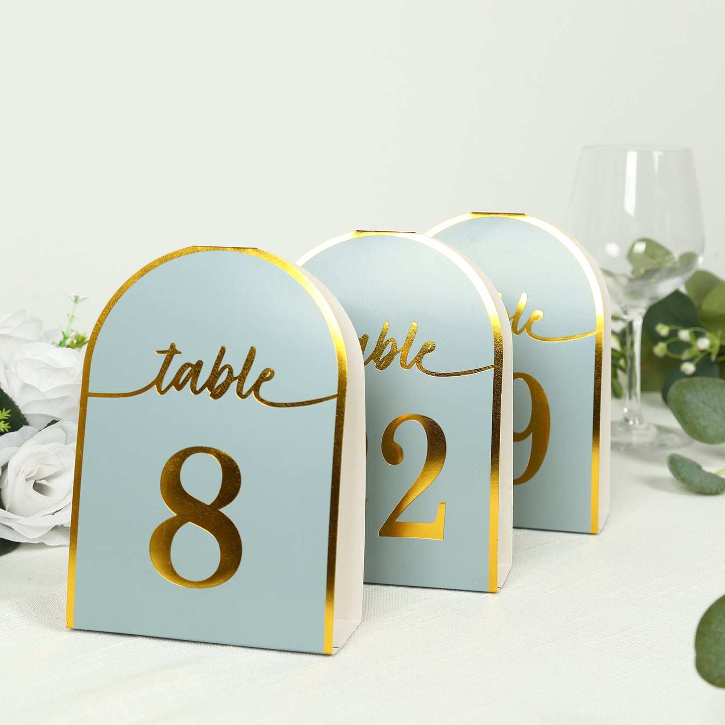 Dusty blue table numbers with metallic gold foil, numbers 1-25.