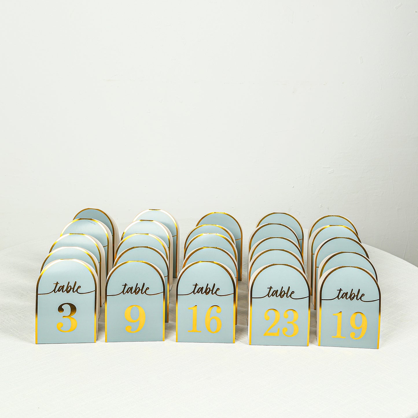 Dusty blue table numbers with metallic gold foil, numbers 1-25.