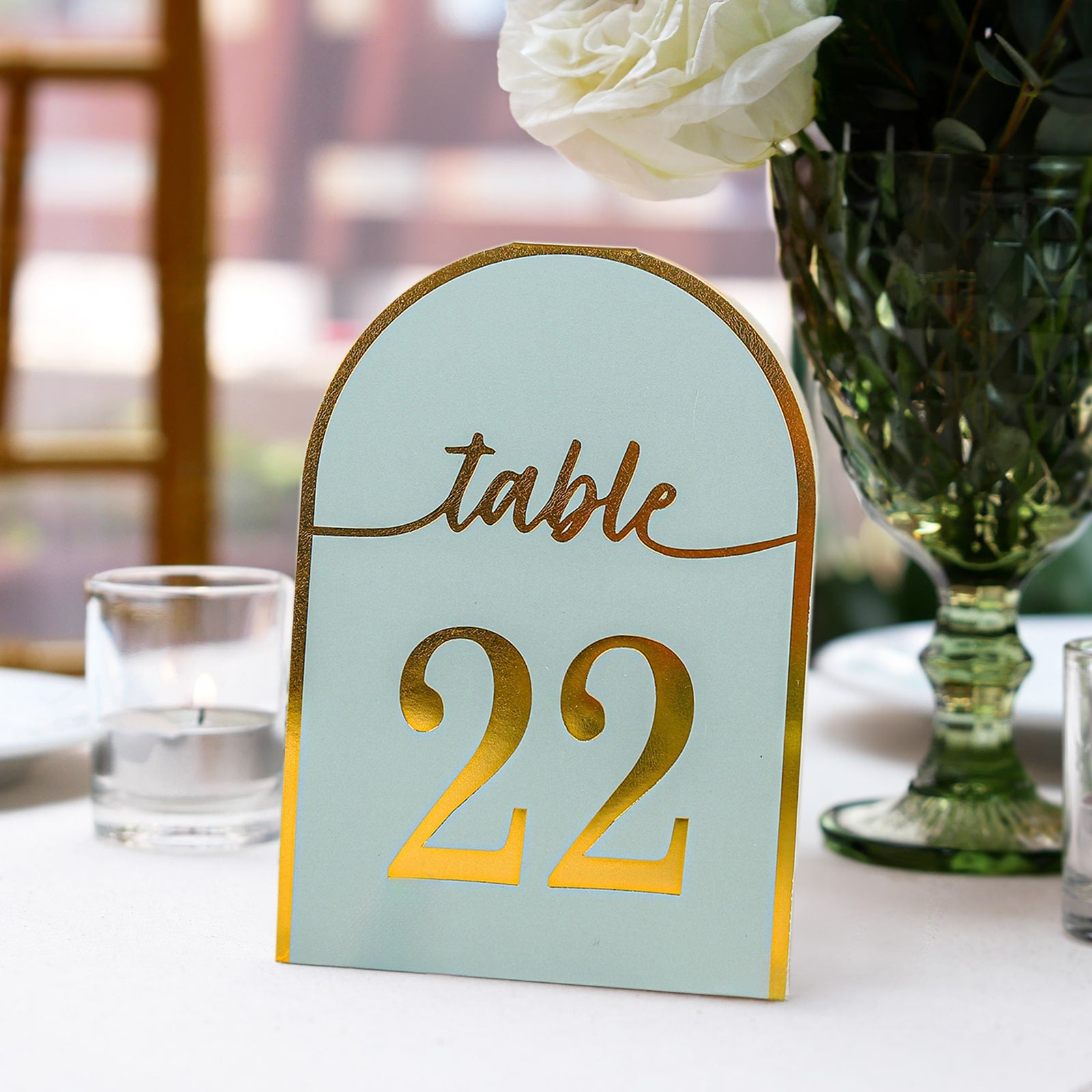 Dusty blue table number card with metallic gold foil, showing number 22.
