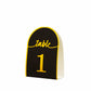 Black and gold disposable table number card, 7 inches tall, for events.