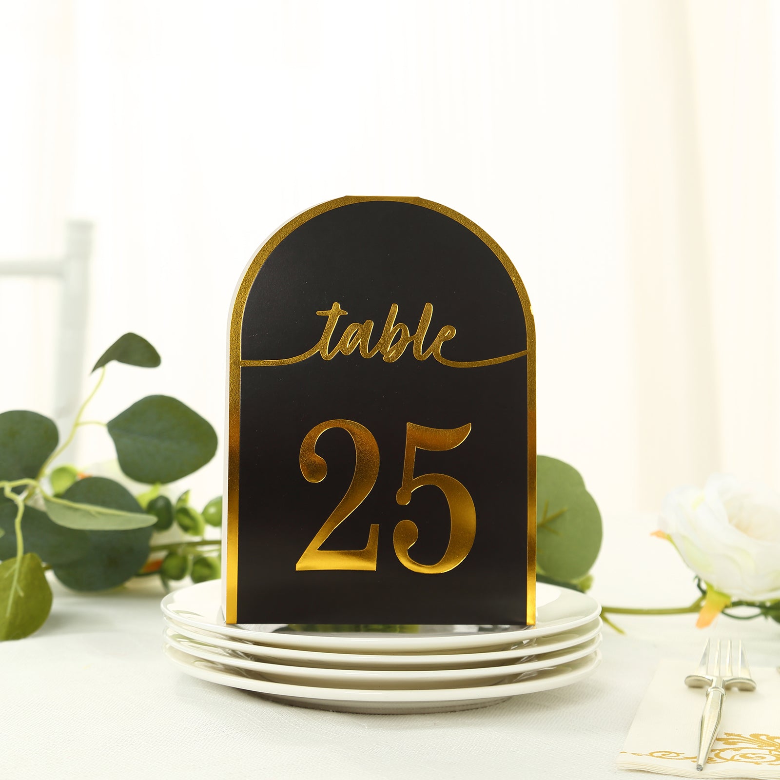 Black and gold double-sided table number 25 on a plate.
