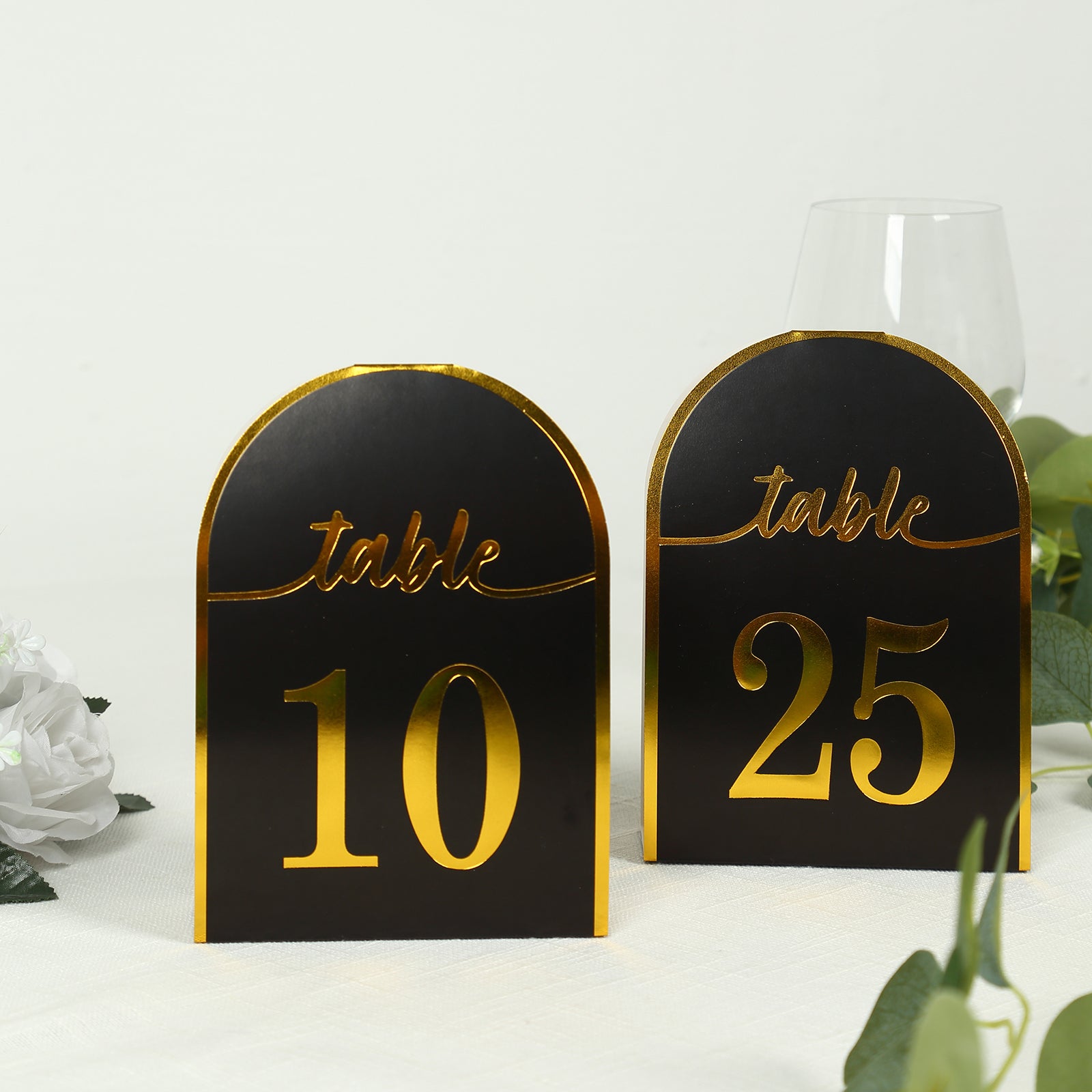 Black table numbers with metallic gold foil, displaying numbers 10 and 25.