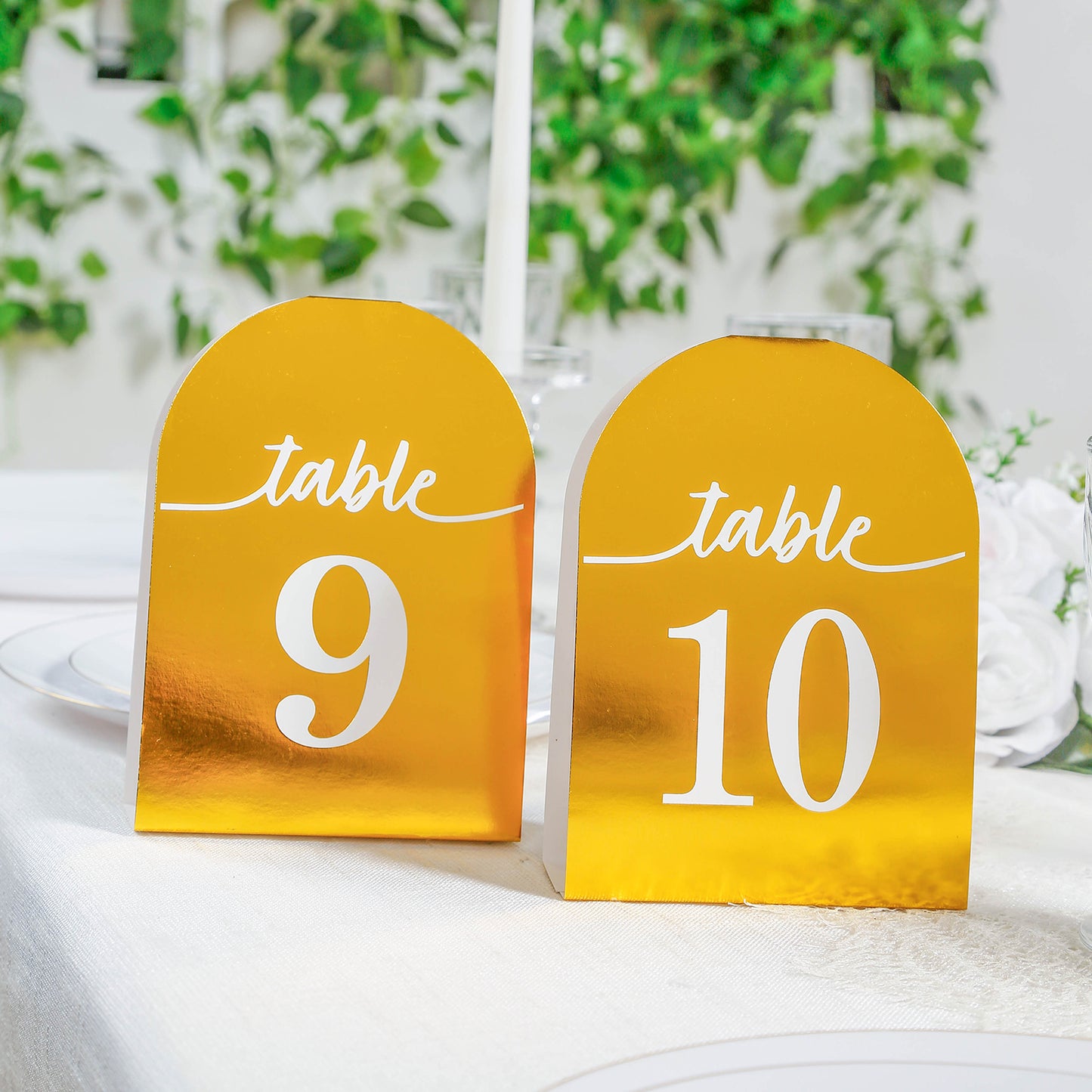 Metallic gold table numbers 9 and 10 on a dining table.