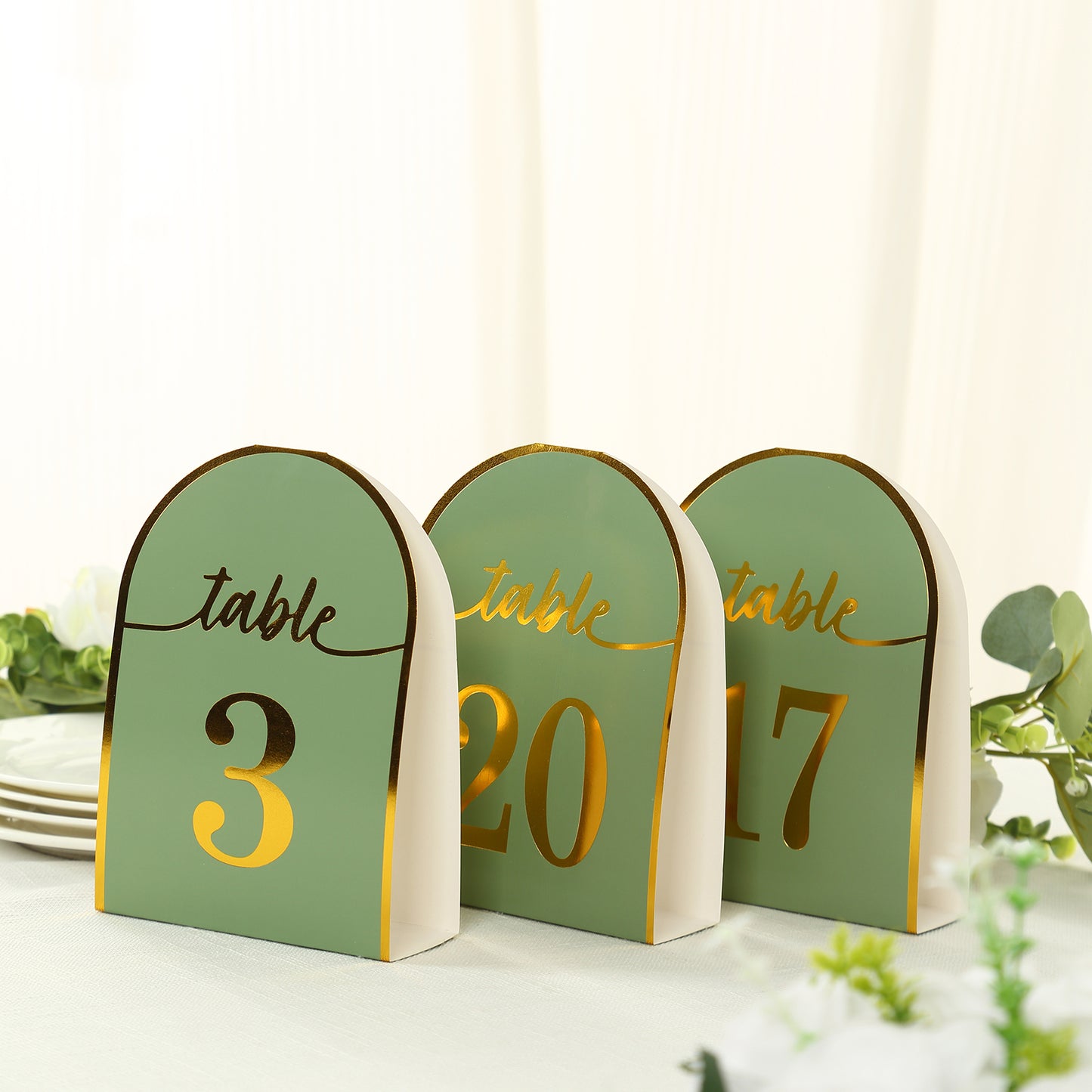 Sage green table numbers with gold foil, numbered 1-25, for elegant events.
