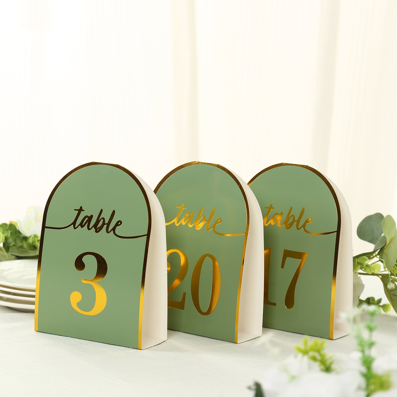 Sage green table numbers with gold foil, numbered 1-25, for elegant events.