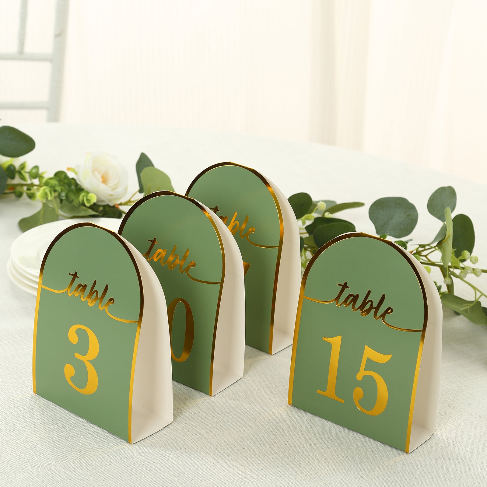 Sage green disposable table numbers with metallic gold foil numbers.