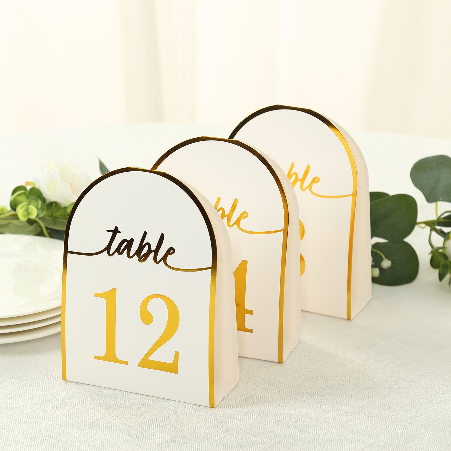 White double-sided table numbers with metallic gold foil, numbered 1-25.