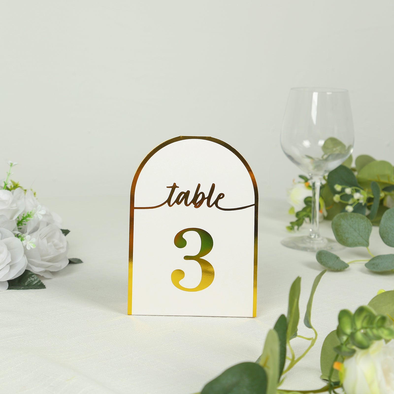 White and metallic gold table number card with number 3.