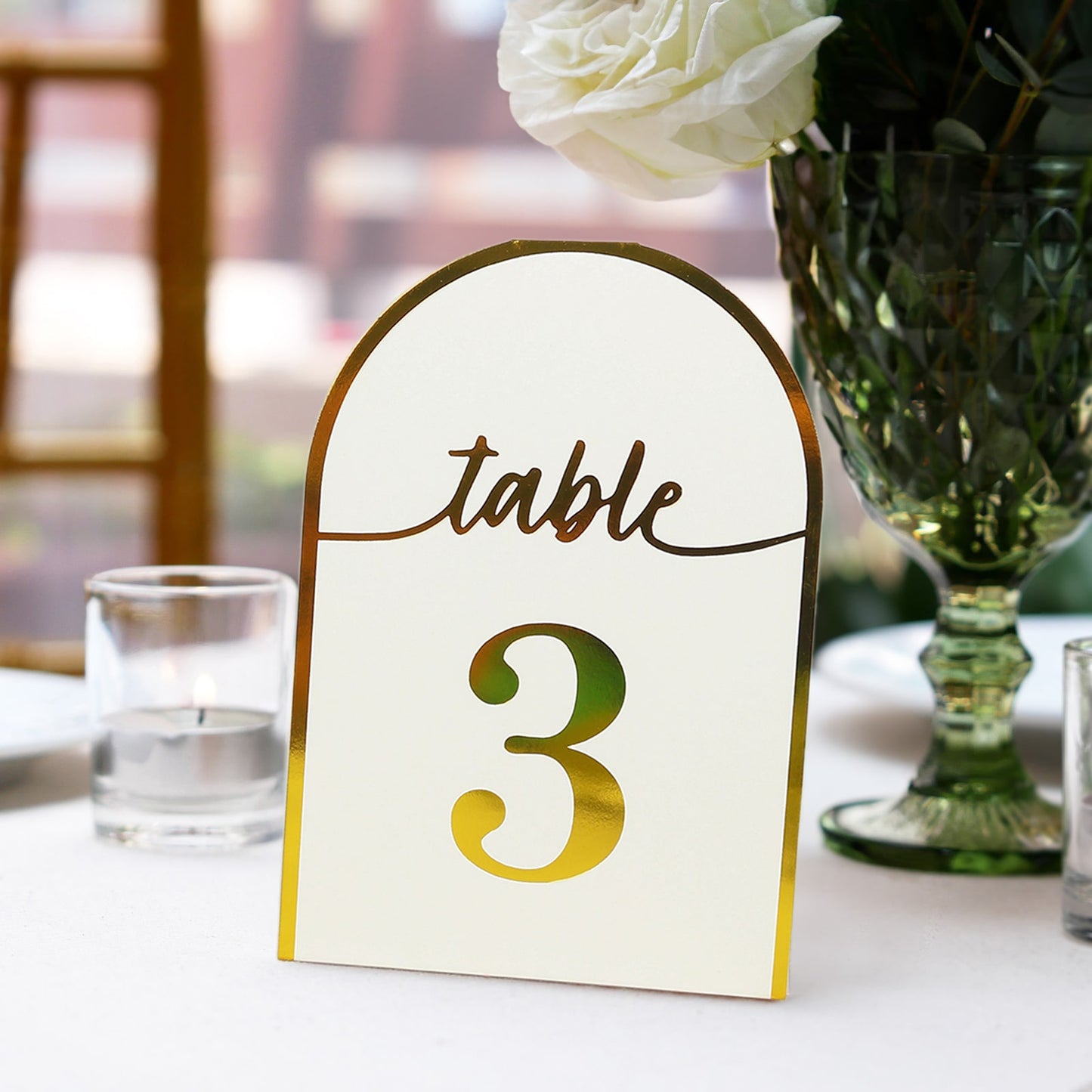 White disposable table number card with metallic gold foil number 3.