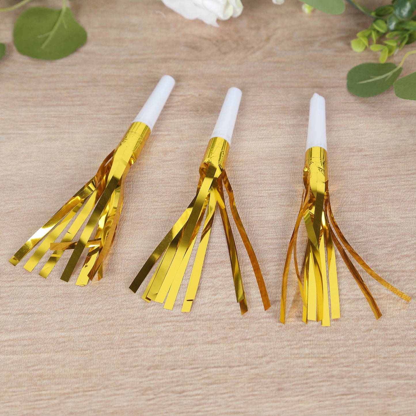 Gold metallic party horn noisemakers with tassels for events.