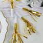 Gold metallic party horn noisemakers with tassels for celebrations.