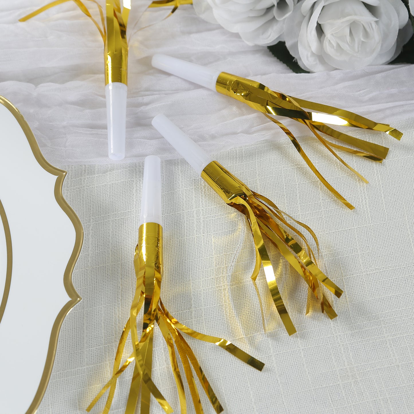 Gold metallic party horn noisemakers with tassels for celebrations.