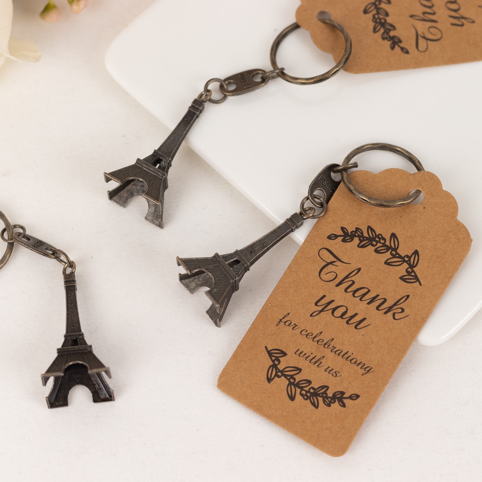 Bronze Eiffel Tower keychains with thank you tags, perfect for wedding favors.