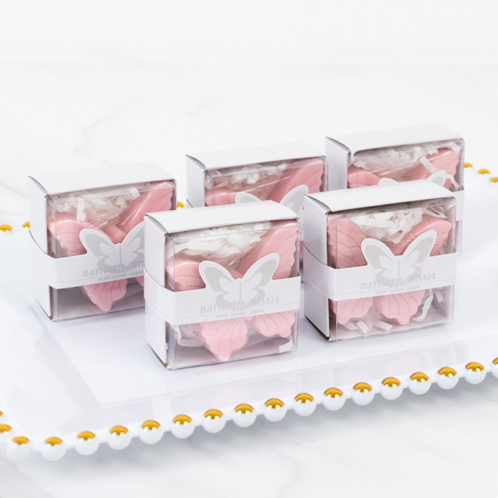 Blush butterfly soap favors in gift boxes for baby showers.
