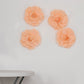 Blush artificial foam DIY craft roses on a wall.