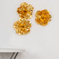 Large metallic gold artificial foam craft roses on a wall.